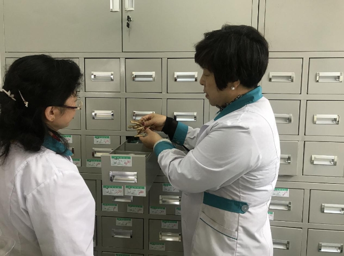 圖為王君蘭（右）和店員張俊麗檢查中藥飲片是否蟲蛀霉變。