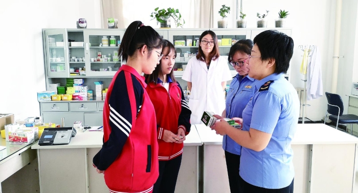 圖為執(zhí)法人員向?qū)W生普及安全用藥知識。