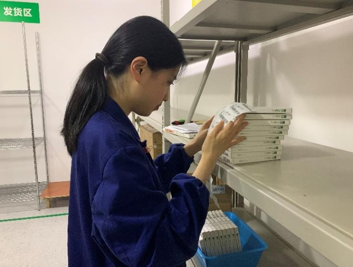 圖為金華市中心醫(yī)院工作人員將追溯二維碼粘貼到醫(yī)療器械包裝盒上。何璇 攝