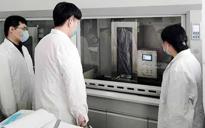 圖為吉林器械所檢驗(yàn)人員開展疫情防護(hù)用品的阻燃試驗(yàn)。