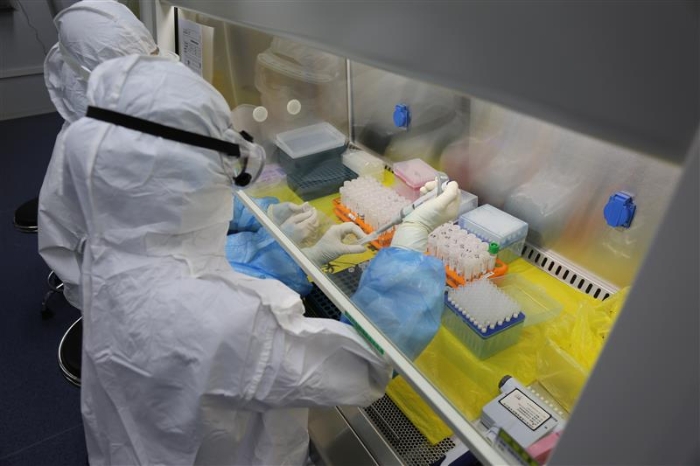 “火眼”自動(dòng)化提取室內(nèi)，檢測(cè)人員在進(jìn)行自動(dòng)化核酸提取的樣本準(zhǔn)備。