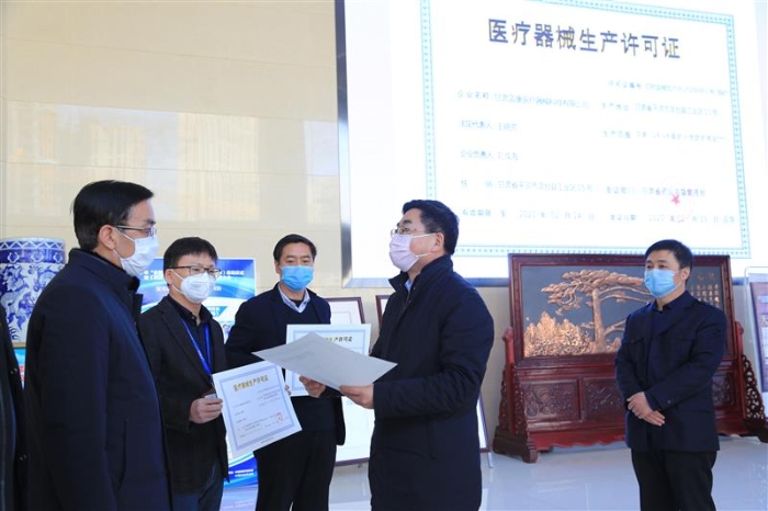 圖為甘肅省藥監(jiān)局副局長王宗偉（右二）為三家企業(yè)發(fā)放臨時《醫(yī)療器械注冊證》和《醫(yī)療器械生產(chǎn)許可證》 （中國食品藥品網(wǎng)記者丁怡媛 攝）