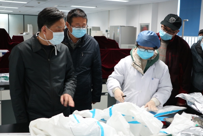 圖為湖北省藥監(jiān)局鄧小川（左一）帶領(lǐng)武漢分局執(zhí)法人員對(duì)防護(hù)用品生產(chǎn)企業(yè)進(jìn)行現(xiàn)場(chǎng)檢查。（湖北省藥監(jiān)局武漢分局供圖）