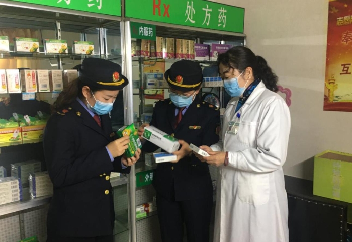 監(jiān)管人員正在藥品經(jīng)營(yíng)企業(yè)檢查該企業(yè)藥品儲(chǔ)存情況