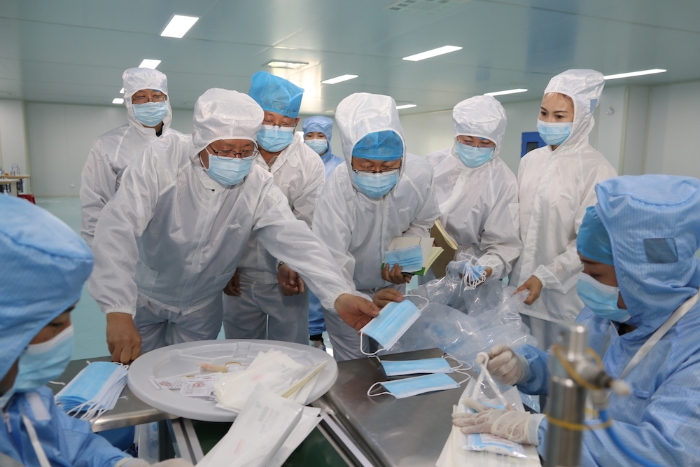 “五_一”小長(zhǎng)假期間，新疆維吾爾自治區(qū)藥監(jiān)局黨組書(shū)記、局長(zhǎng)張鈺祥（左一）帶隊(duì)赴哈密市調(diào)研口罩生產(chǎn)企業(yè)。（馬少賓 攝）