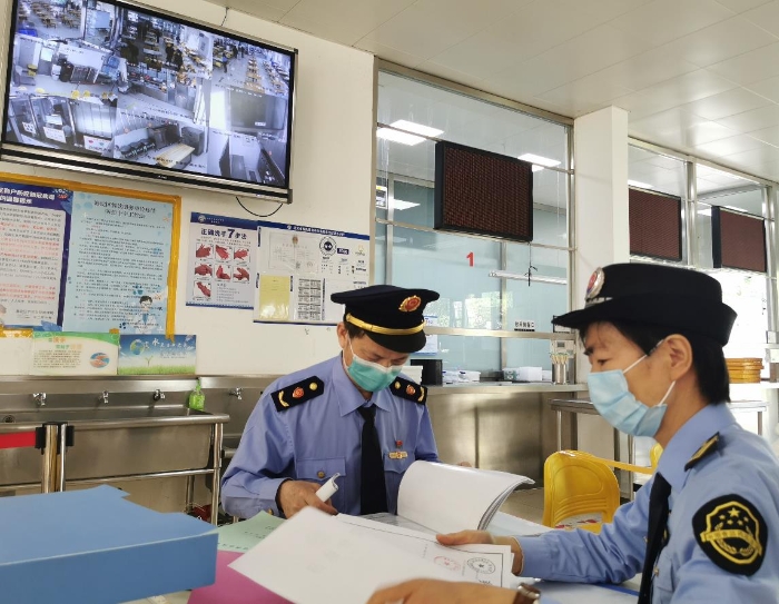 海淀區(qū)市場(chǎng)監(jiān)管局監(jiān)管人員檢查學(xué)校食堂進(jìn)貨記錄。（中國食品藥品網(wǎng)記者王曉冬 攝）