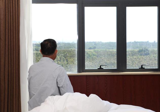 圖為患者盼來(lái)救命藥后凝望窗外。