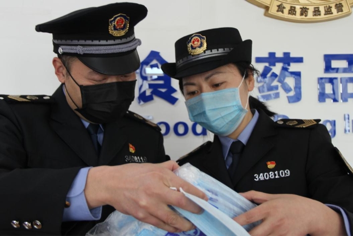 執(zhí)法人員在查驗假冒醫(yī)用口罩 孫斌園 攝 執(zhí)法人員在查驗假冒醫(yī)用口罩 孫斌園 攝