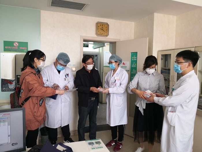 工作人員向醫(yī)護(hù)人員贈送化妝品安全科普宣傳手冊