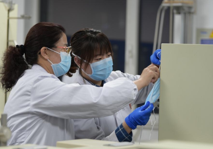 技術(shù)人員對口罩等疫情防控用品進(jìn)行檢驗(yàn)。