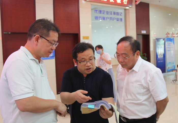上官新晨（右一）在鷹潭市行政服務(wù)中心詳細了解鷹潭市局在簡化審批流程、優(yōu)化服務(wù)等方面的工作舉措。