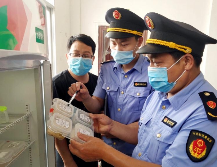 圖為6月8日該局執(zhí)法人員在一鄉(xiāng)鎮(zhèn)學(xué)校食堂檢查食品留樣。