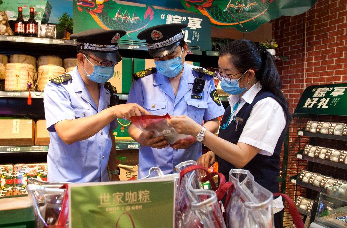 東城區(qū)市場(chǎng)監(jiān)管局執(zhí)法人員在超市檢查粽子保質(zhì)期。