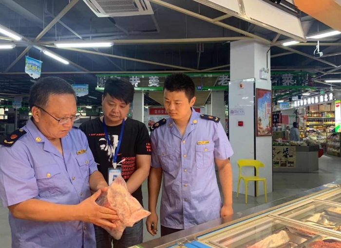圖為該局執(zhí)法人員在一家農(nóng)貿(mào)市場冷凍食品專柜進(jìn)行檢查。