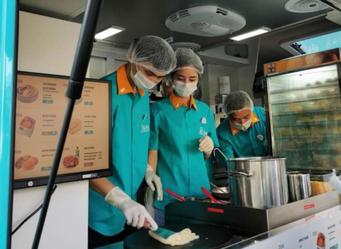 “逸小兔”流動(dòng)早餐車的店員正在為顧客備餐。新華網(wǎng)發(fā)（熊多多 攝）