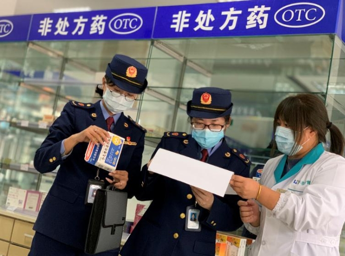 圖為該局執(zhí)法人員對發(fā)燒類藥品銷售登記進(jìn)行檢查。