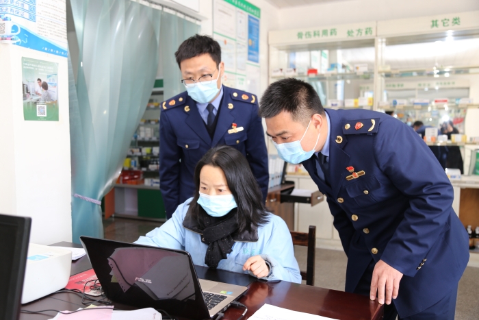 圖為執(zhí)法人員在查看進貨臺賬