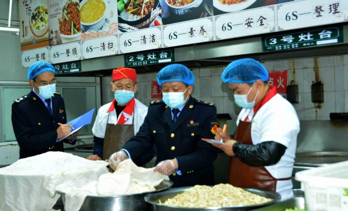 圖為4月7日，執(zhí)法人員在檢查某學(xué)校食堂操作間衛(wèi)生。