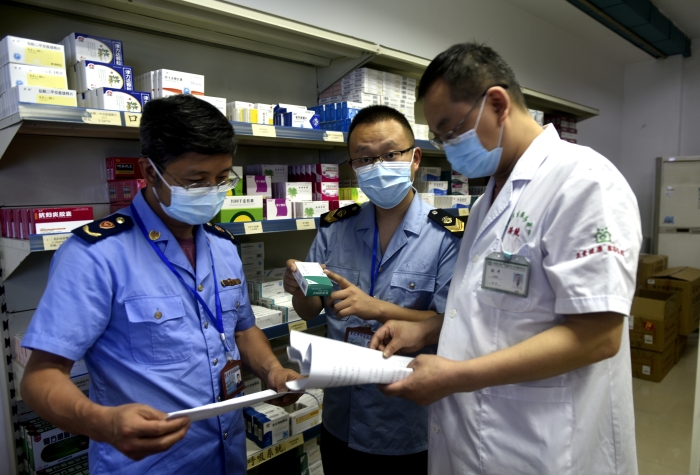 圖為執(zhí)法人員按照“中選藥品”目錄抽取藥品抽檢樣本。