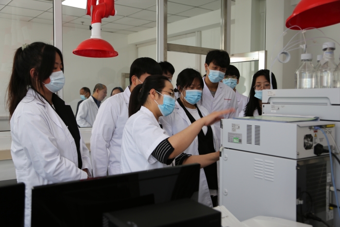 圖為工作人員介紹化妝品檢驗設(shè)備使用方法。