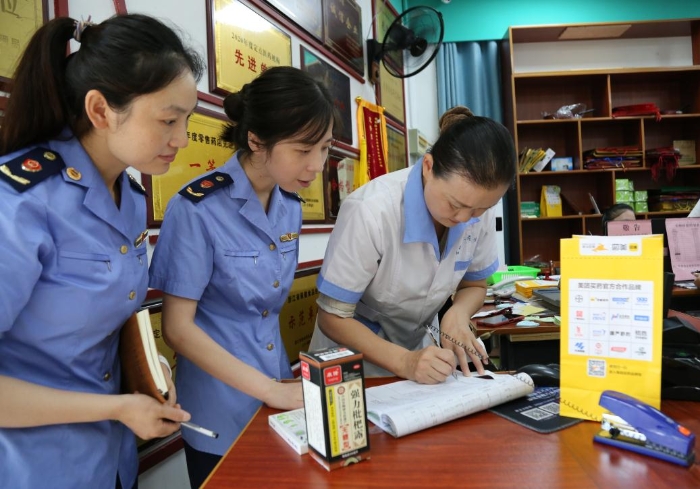 圖為執(zhí)法人員查看網(wǎng)絡(luò)藥品銷售登記，核對處方藥處方單。