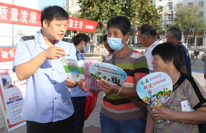 圖為執(zhí)法人員向群眾宣講食品安全知識(shí)。