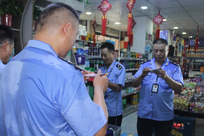 圖為7月11日該局執(zhí)法人員在一家超市檢查食品生產(chǎn)日期和保質(zhì)期。