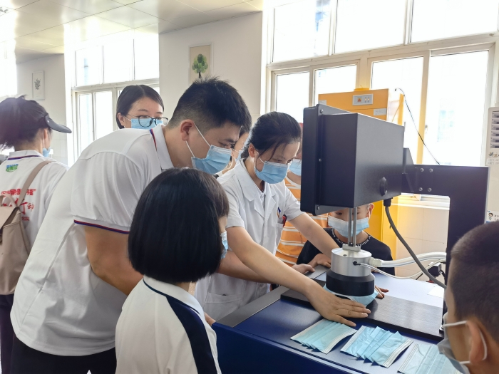 圖為技術(shù)人員在講解口罩的檢驗(yàn)方法和原理。（喻燦華 攝）