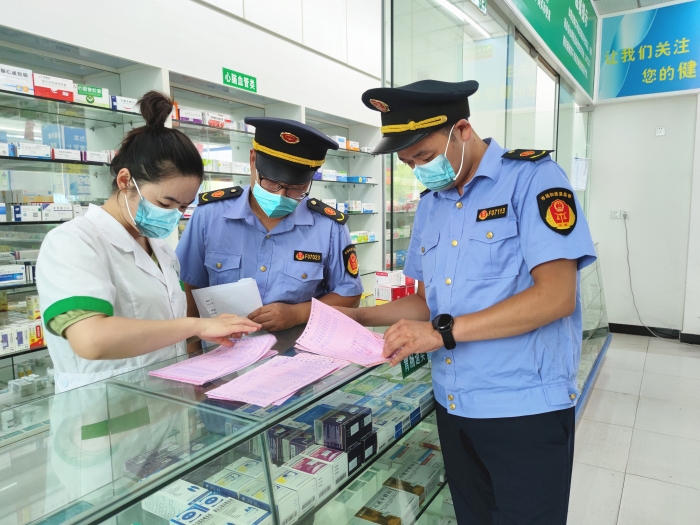 圖為監(jiān)管人員在一家藥店檢查。