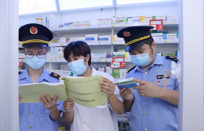 圖為9月13日?qǐng)?zhí)法人員在一家藥店查看網(wǎng)絡(luò)藥品銷售登記情況，并核對(duì)處方藥處方單。