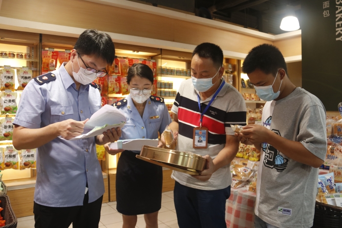 圖為執(zhí)法人員查看月餅質量情況。（柯潔 攝）