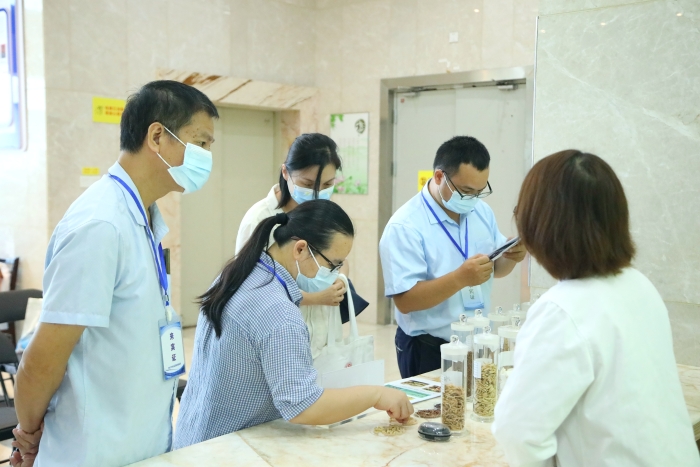 圖為工作人員向市民代表講解中藥材（枸杞、菊花等）真?zhèn)舞b別知識。