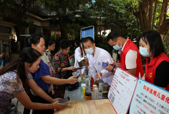 圖為社區(qū)群眾紛紛下載國家藥品監(jiān)督管理局“化妝品監(jiān)管”APP。（程奇攝）