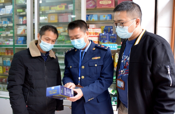 圖為執(zhí)法人員在一藥店檢查“四類藥品”實名登記情況。
