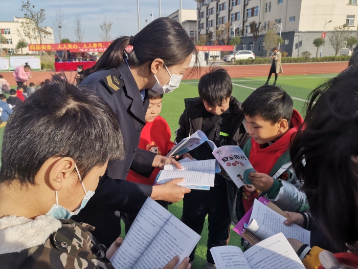 圖為工作人員為小學生講解安全用藥科普知識。