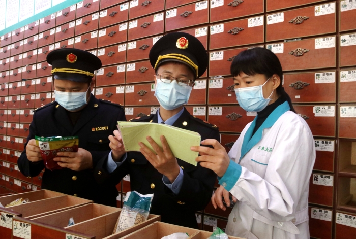 圖為11月24日執(zhí)法人員對一家藥店檢查中藥飲片。