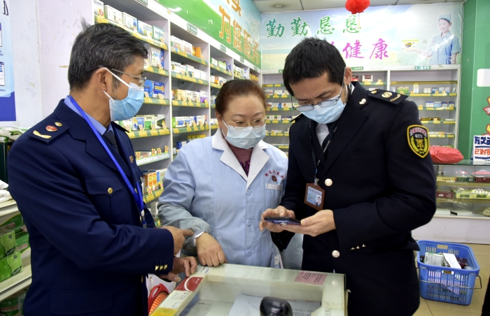 圖為執(zhí)法人員在一家藥店檢查藥品經(jīng)營(yíng)者的智慧監(jiān)管系統(tǒng)的使用情況。