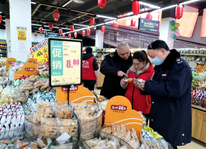 圖為執(zhí)法人員在檢查散裝餅干的生產(chǎn)日期。（王玲玲 攝）
