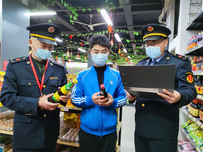 圖為執(zhí)法人員在一家超市檢查調(diào)味品質(zhì)量。