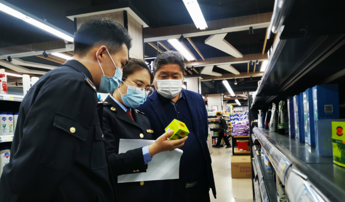 圖為執(zhí)法人員在化妝品銷售現(xiàn)場進行檢查。