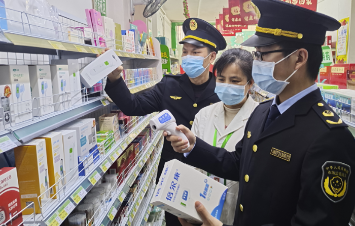 圖為執(zhí)法人員在一家藥店檢查額溫槍。