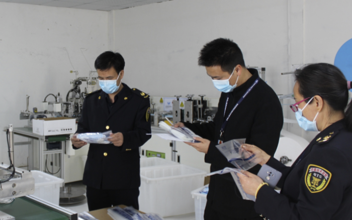 圖為執(zhí)法人員在一家醫(yī)用口罩生產(chǎn)企業(yè)檢查。