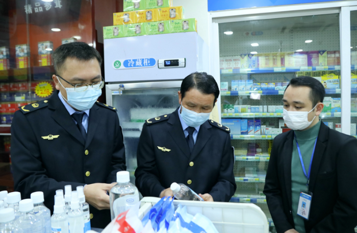 圖為執(zhí)法人員檢查口罩、酒精等防疫物資。