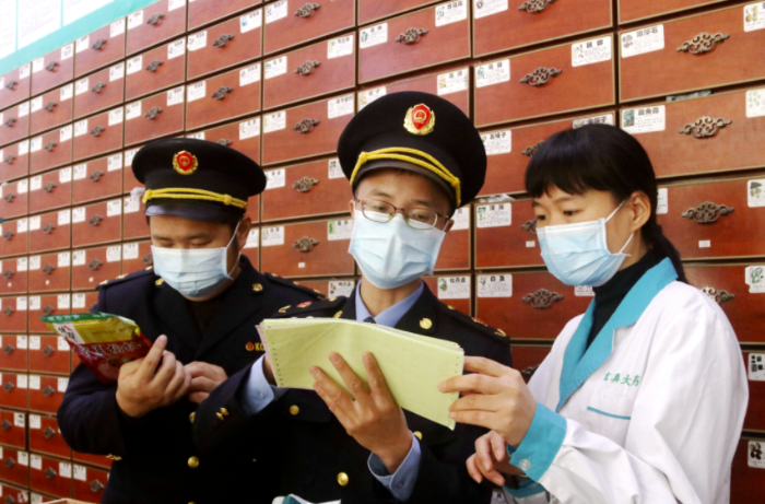 圖為執(zhí)法人員檢查中藥飲片。