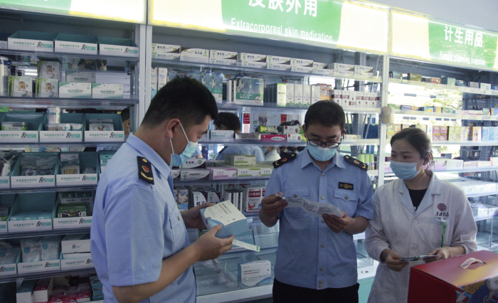 圖為青州市市場(chǎng)監(jiān)管局執(zhí)法人員在一家藥店檢查抗原檢測(cè)試劑盒質(zhì)量。