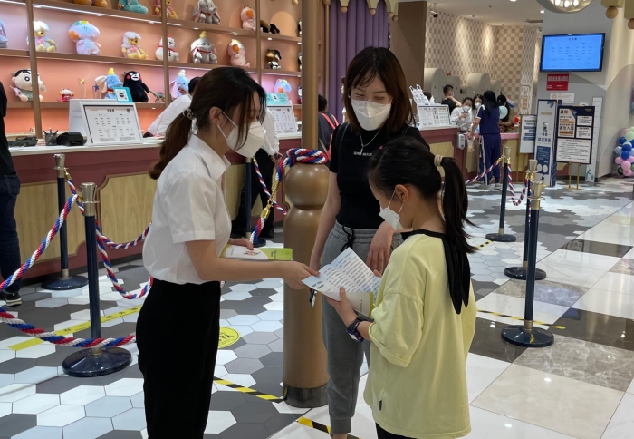 圖為工作人員向兒童發(fā)放兒童化妝品品科普資料（葉陽歡攝）