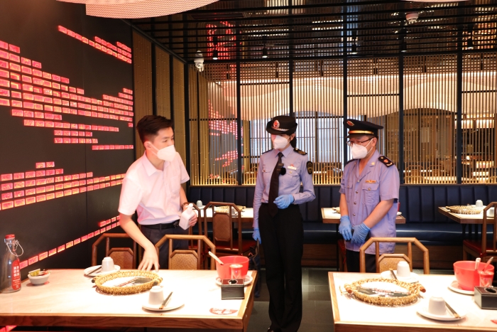 圖為海淀區(qū)市場監(jiān)管局執(zhí)法人員在現(xiàn)場檢查疫情防控及食品安全情況。