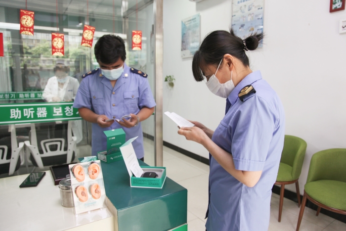 圖為執(zhí)法人員檢查助聽器經(jīng)營企業(yè)產(chǎn)品質(zhì)量安全。