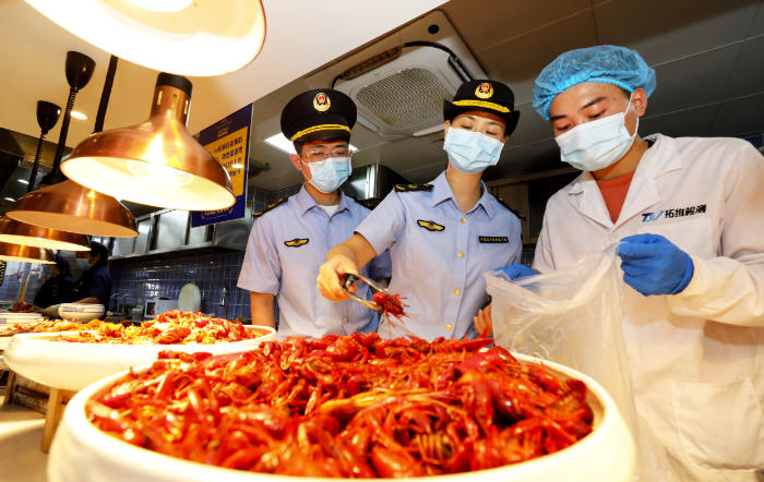 圖為8月2日，淮北市市場監(jiān)督管理部門工作人員在夜市餐飲街區(qū)現(xiàn)場取樣。