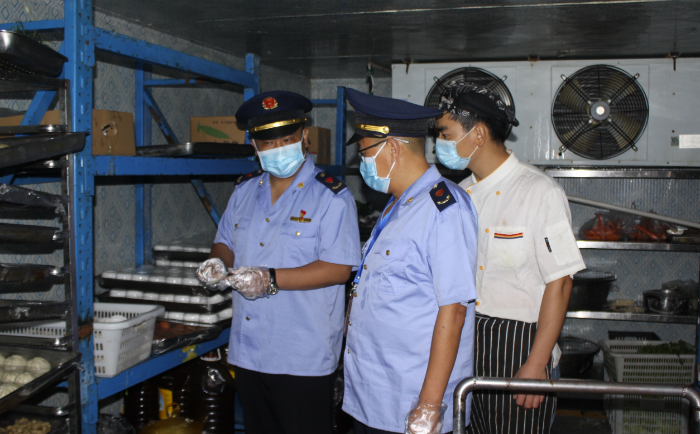 圖為該局執(zhí)法人員在一學校食堂檢查食品安全制度落實情況。